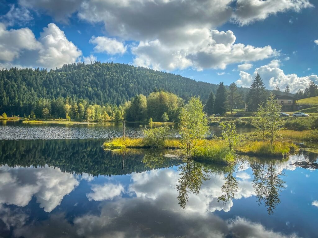 Beautiful clouds reflection in water of Lispach lake in the La Bresse, Vosges